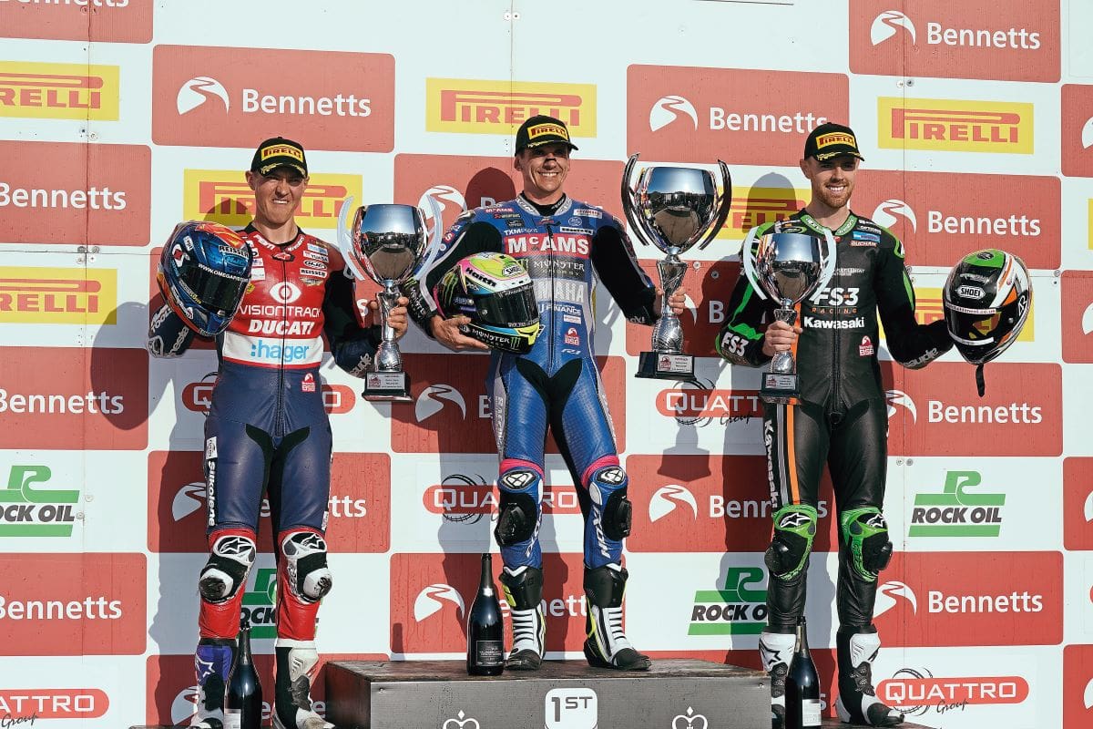 Jason on the podium holding a trophy.